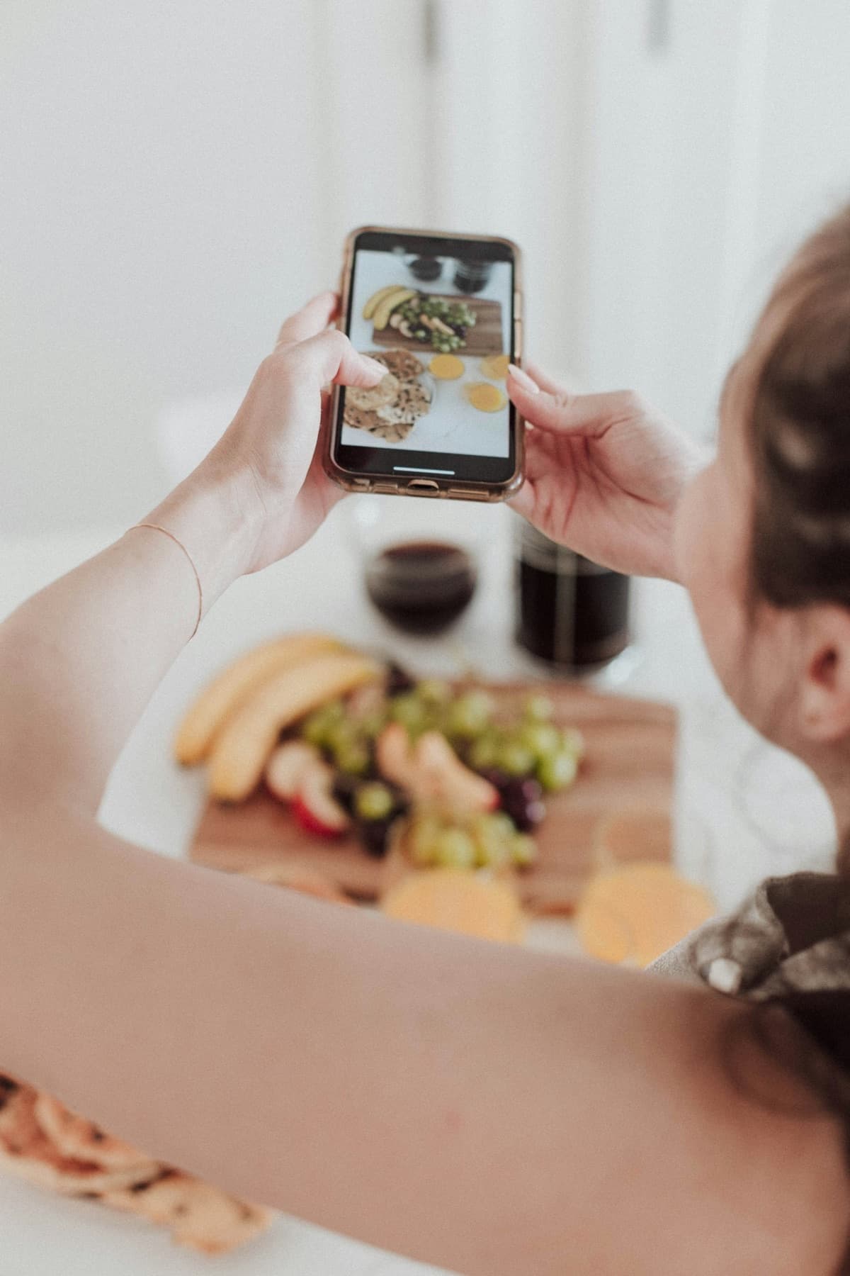 Una ragazza fotografa con il telefono il piatto che ha davanti